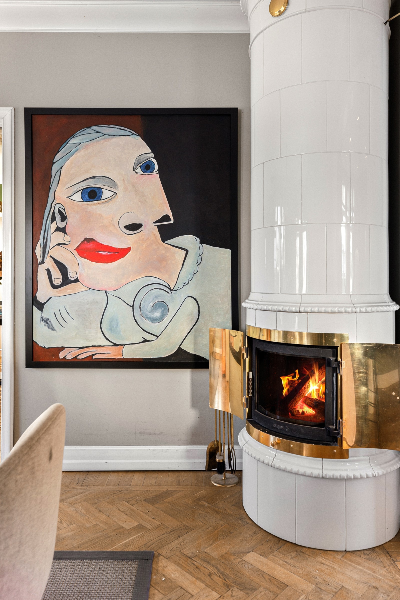 Spisestuen smykkes av en høyreist kakkelovn med messingdører.