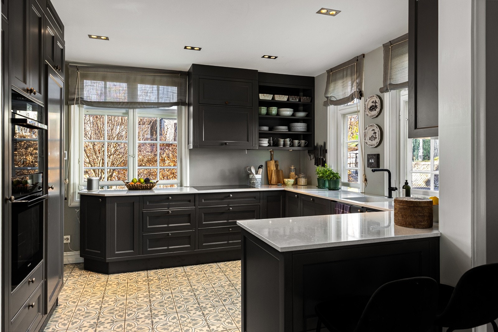 Kjøkkenet gir et eksklusivt inntrykk, rikelig med skapplass og god arbeidsflyt langs benkeplater i lys granitt.