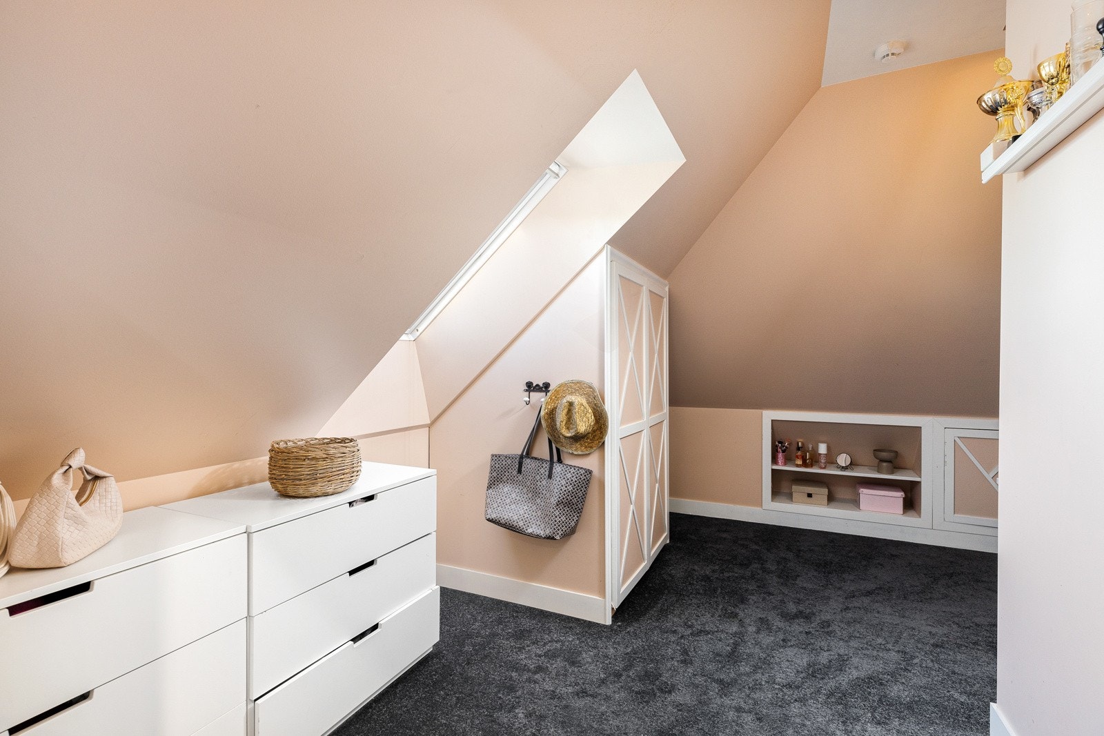 Det ene soverommet på loftet har plassbygde skap og hyller i kneveggene (ikke byggemeldt).