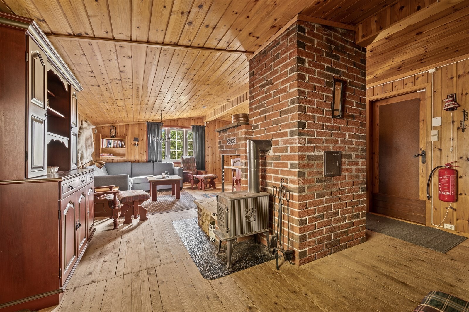 Den romslige stuen har en stor peis som naturlig midtpunkt og åpen løsning mot kjøkkenet. Galleribilde