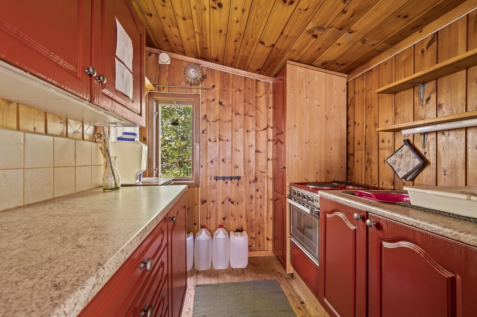 Kjøkkenet er utstyrt med profilert innredning, stekeovn, kjøleskap og fryser. Galleribilde