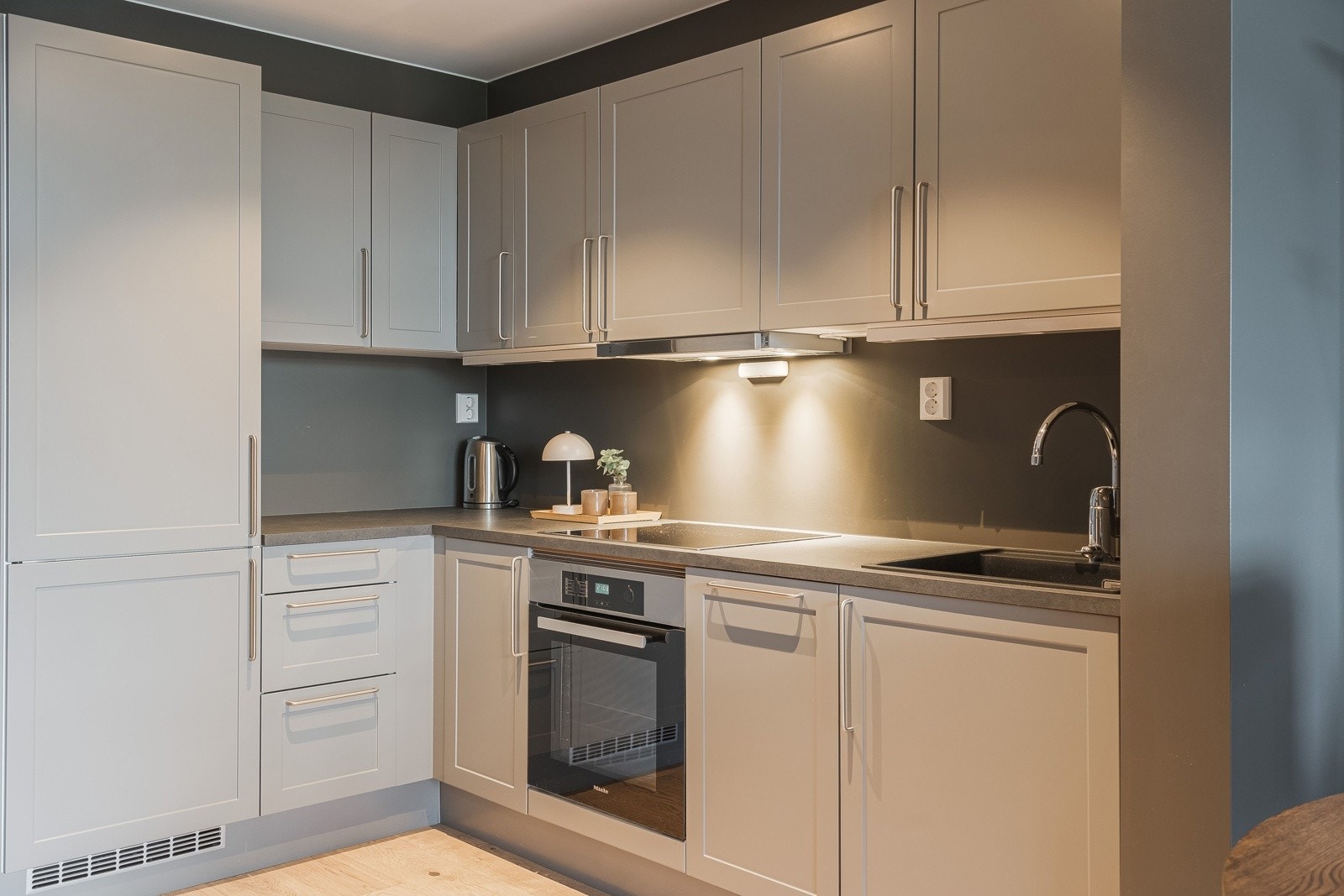 Innredningen passer fint inn i leilighetens stil og har rette profilfronter og lamintert benkeplate med fine arbeidsflater Galleribilde