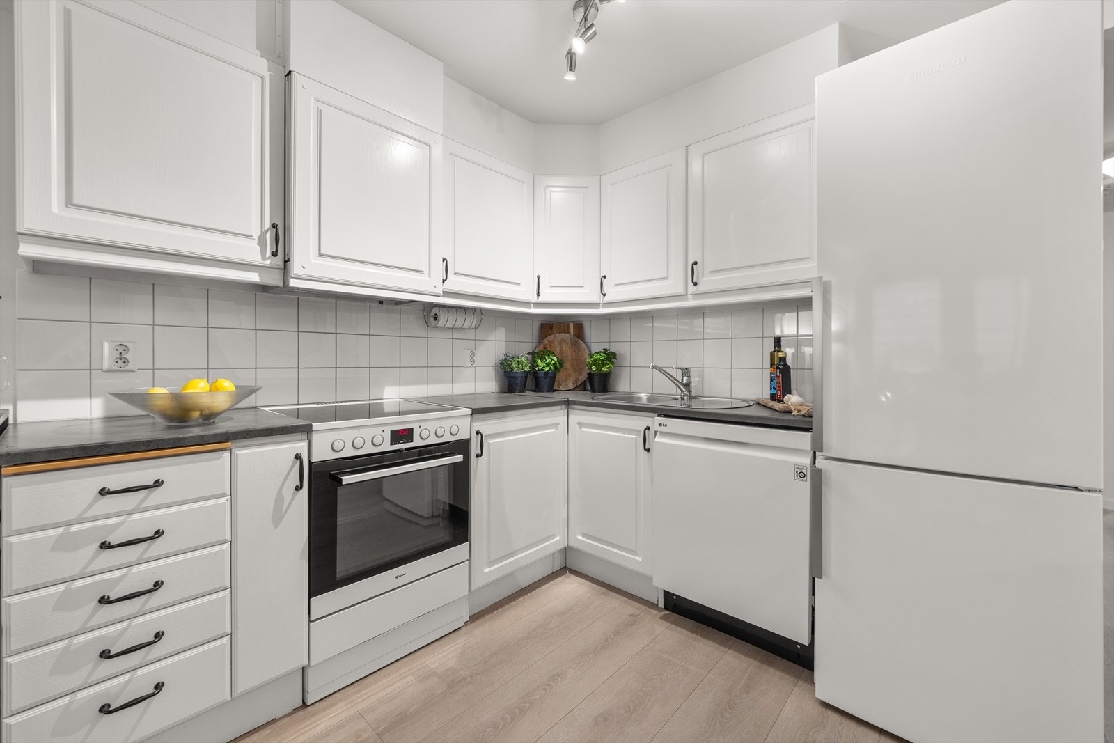 Kjøkken med profilerte fronter, flislagt over kjøkkenbenk og benkeplate i laminat fra 2020 Galleribilde