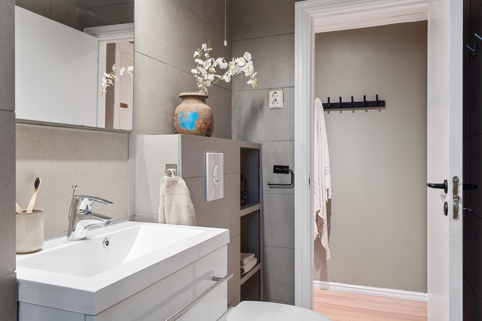 Badet har innredning med nedfelt servant, veggfestet toalett og dusjhjørne. Galleribilde