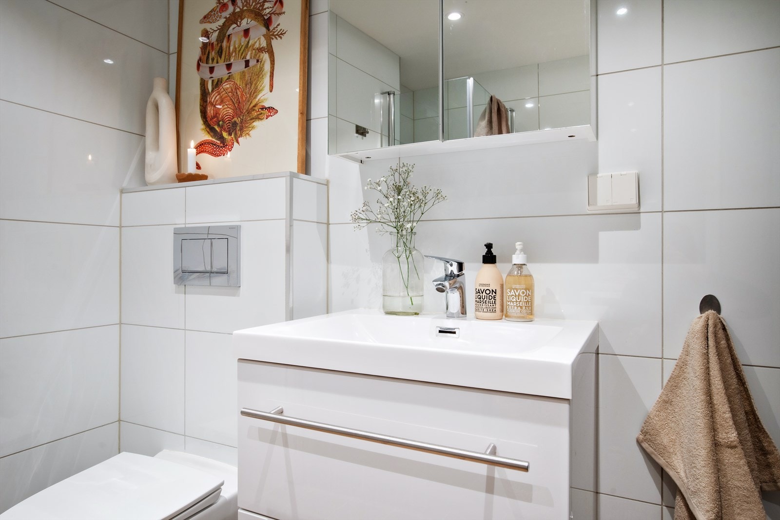 Badet er utstyrt med heldekkende servant med blandebatteri og overskap med speil og lys, vegghengt toalett, dusjnisje med innfellbare glassdører og opplegg for vaskemaskin. Galleribilde