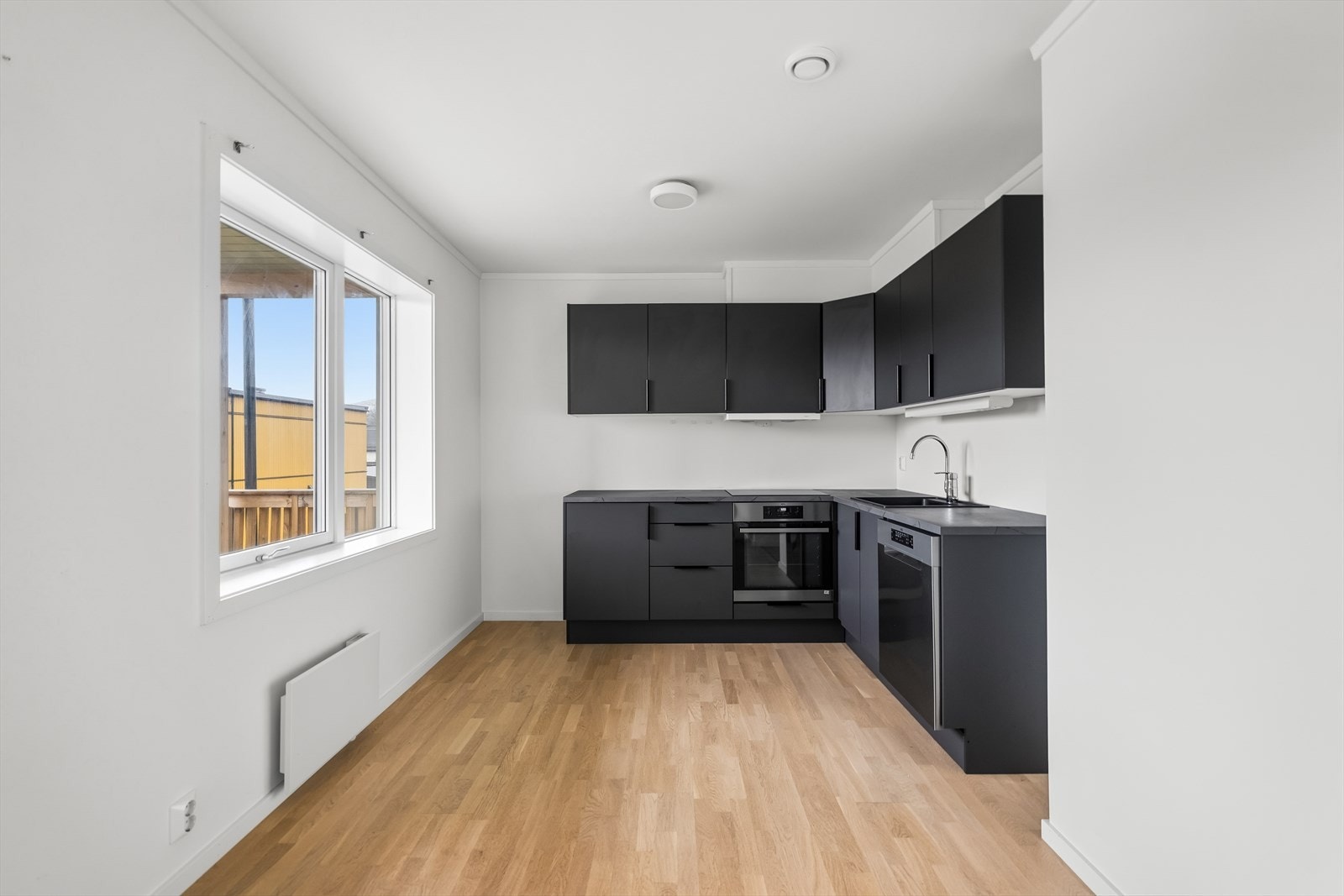 Fint vinkelformet kjøkken med god skap- og benkeplass. Galleribilde