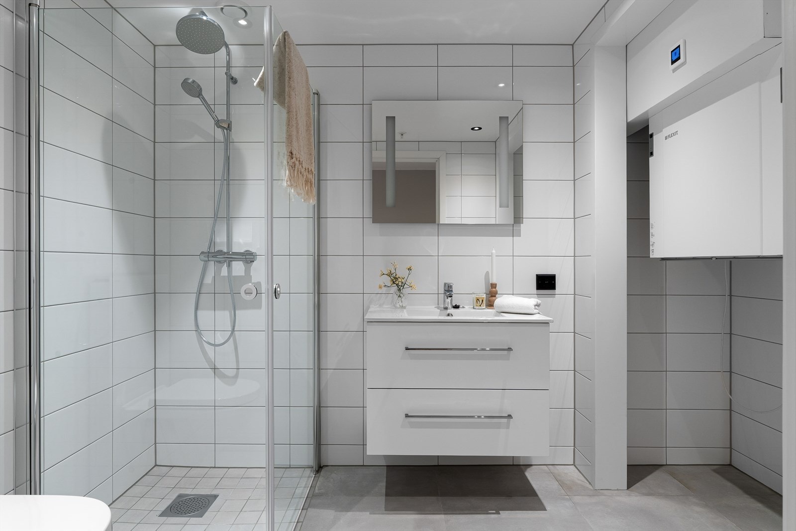 Flott helfliset bad med vegghengt wc, dusjhjørne og varme i gulv for ekstra komfort. Badet fremstår som arealeffektivt med pen baderomsinnredning i hvit utførelse. Galleribilde