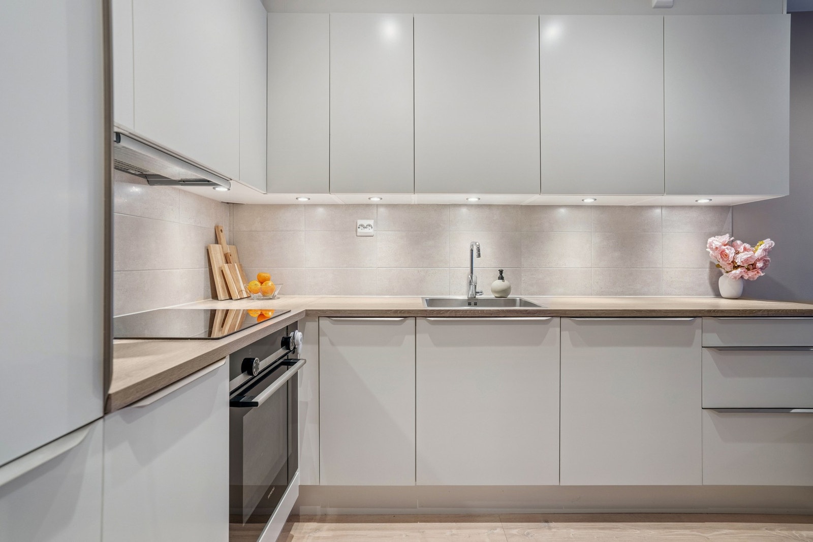 Flislagt vegg mellom benkeplate og overskap, samt spotter under overskapene som skaper godt med arbeidslys. Galleribilde