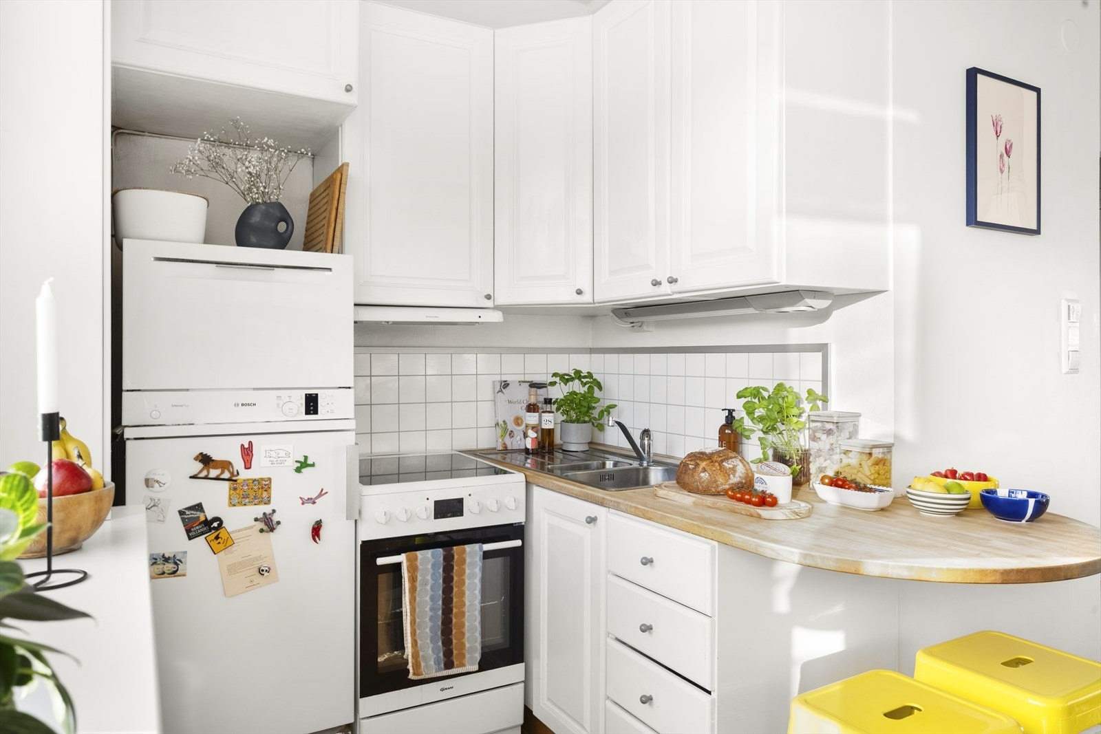 Kjøkkeninnredningen har hvite fronter og heltre benkeplate med nedfelt kum. Kjøkkenet er utstyrt med frittstående kjøl/fryseskap, oppvaskmaskin og komfyr. Galleribilde