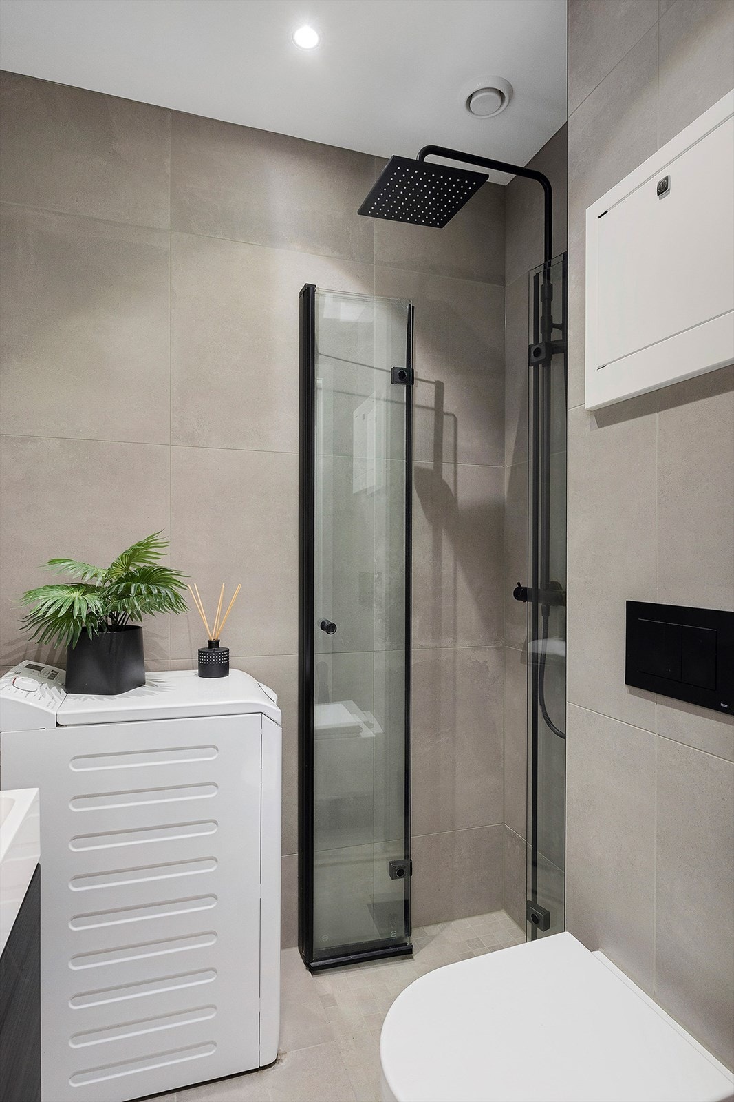 Dusjnisje med innfellbare dører i herdet glass. Toppmatet vaskemaskin medfølger. Galleribilde