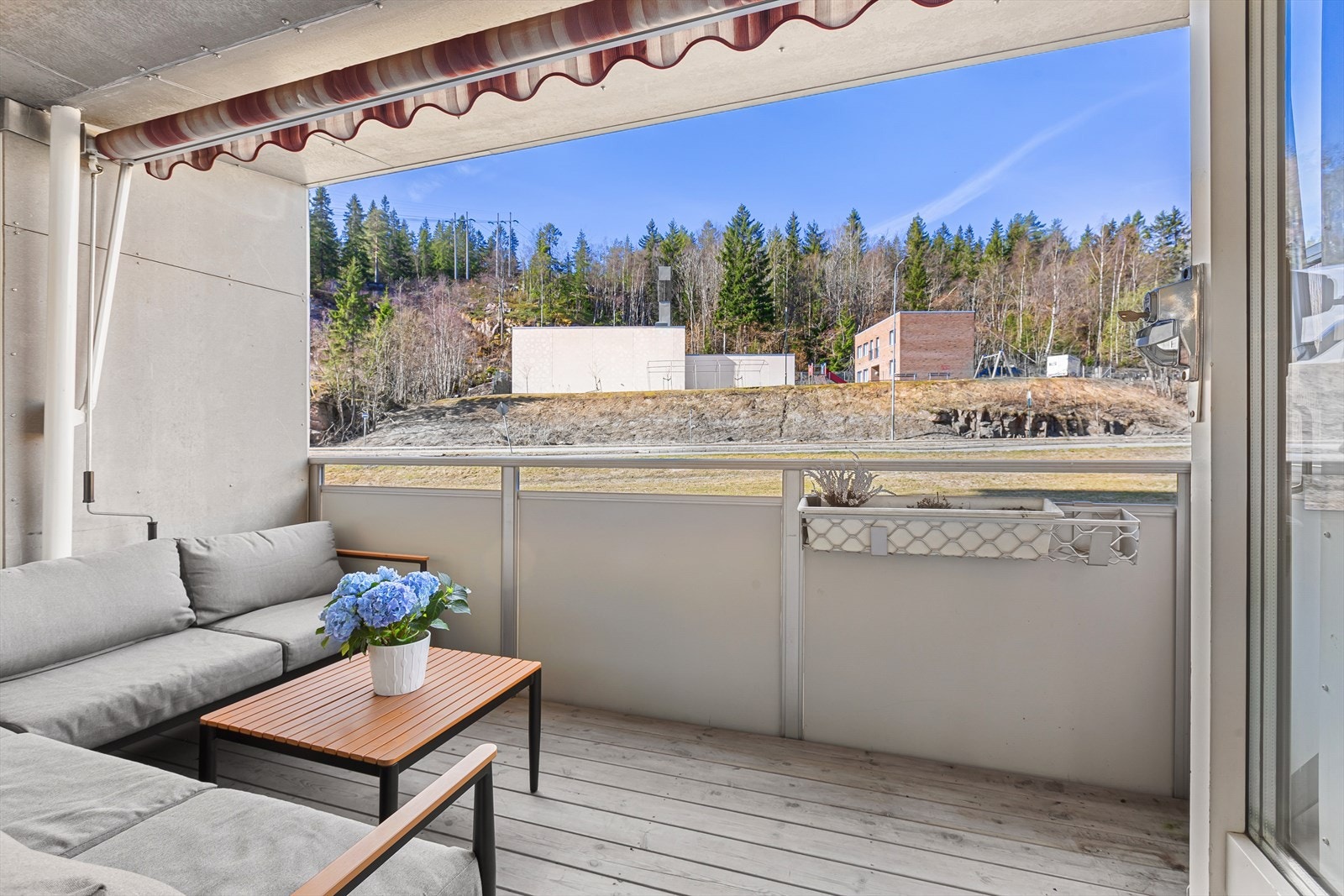 Balkongen har utsyn mot naturomgivelser og nærliggende boligområde Galleribilde