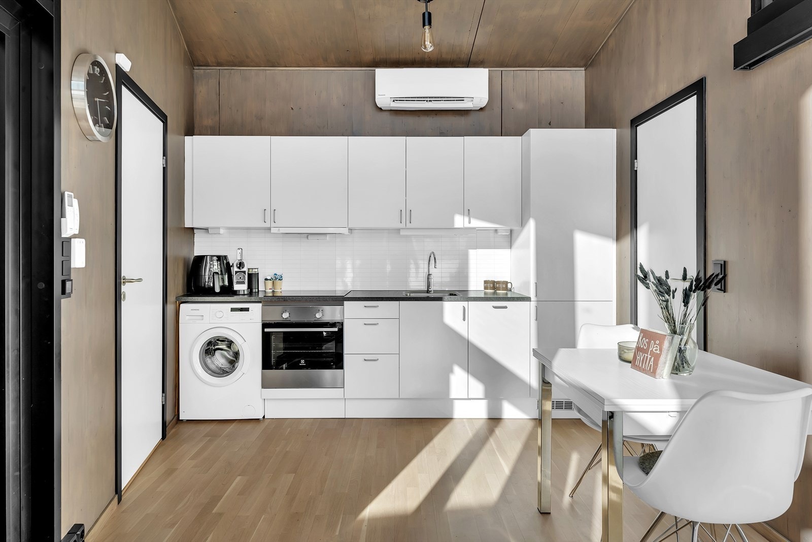 Kjøkkenet har innredning med glatte, hvite fronter. Det er integrert kjøl/fryseskap, oppvaskmaskin, induksjonstopp, stekeovn og opplegg. Galleribilde