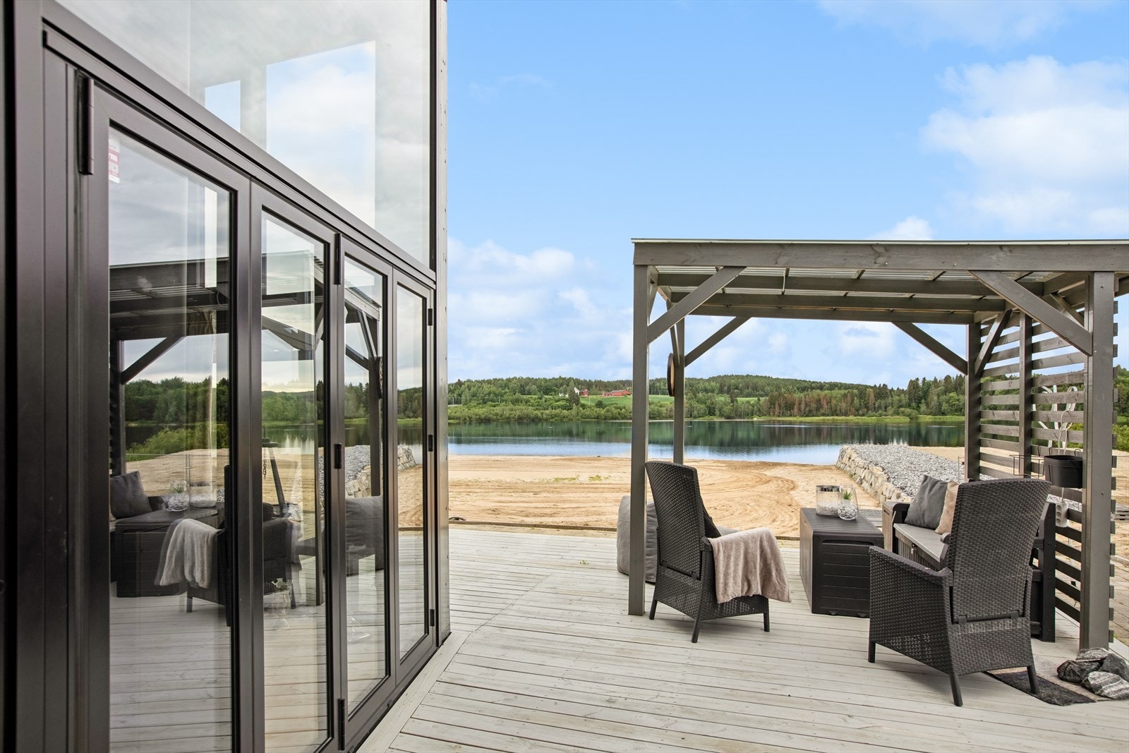 Du ønskes velkommen inn via en romslig platting med utsyn mot stranda. Galleribilde