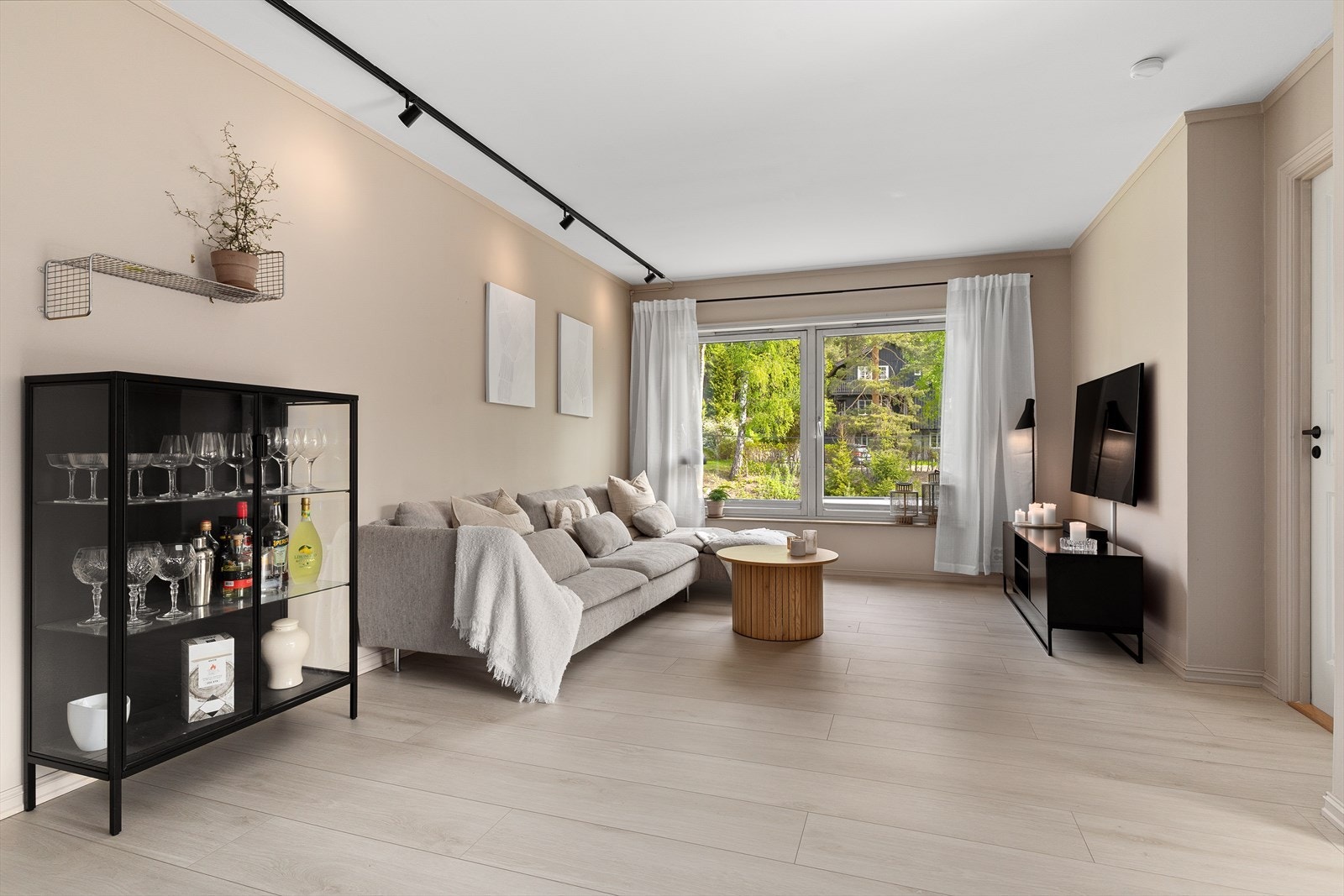 Lun og fin tv-krok med store vinduer som gir fint lysinnslipp Galleribilde