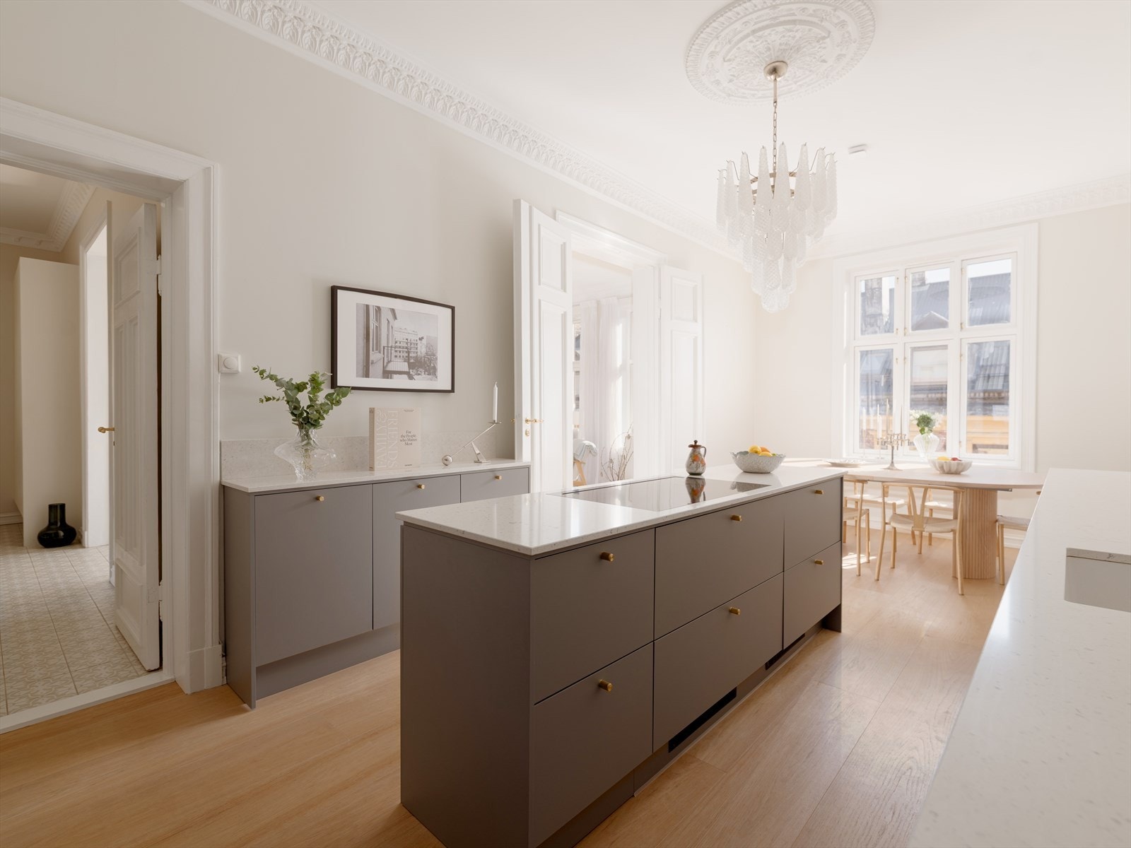 Den åpne løsningen gir både funksjonalitet og eleganse. Kjøkkenøyen fungerer både som arbeidsplass og naturlig samlingspunkt for familie og venner. Galleribilde