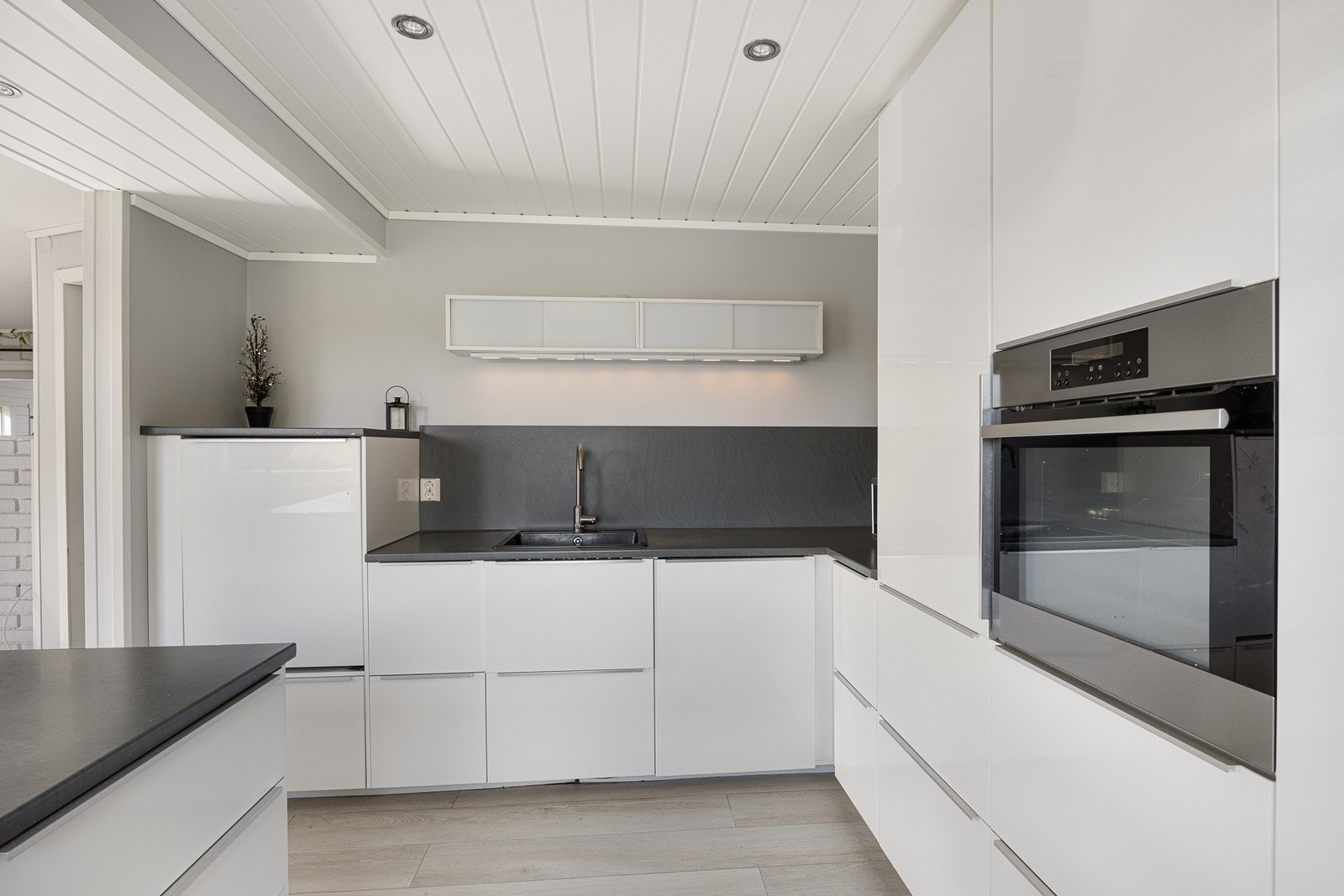 Rommet er i en gjennomført stil med høyglans fronter og laminat benkeplate. Galleribilde