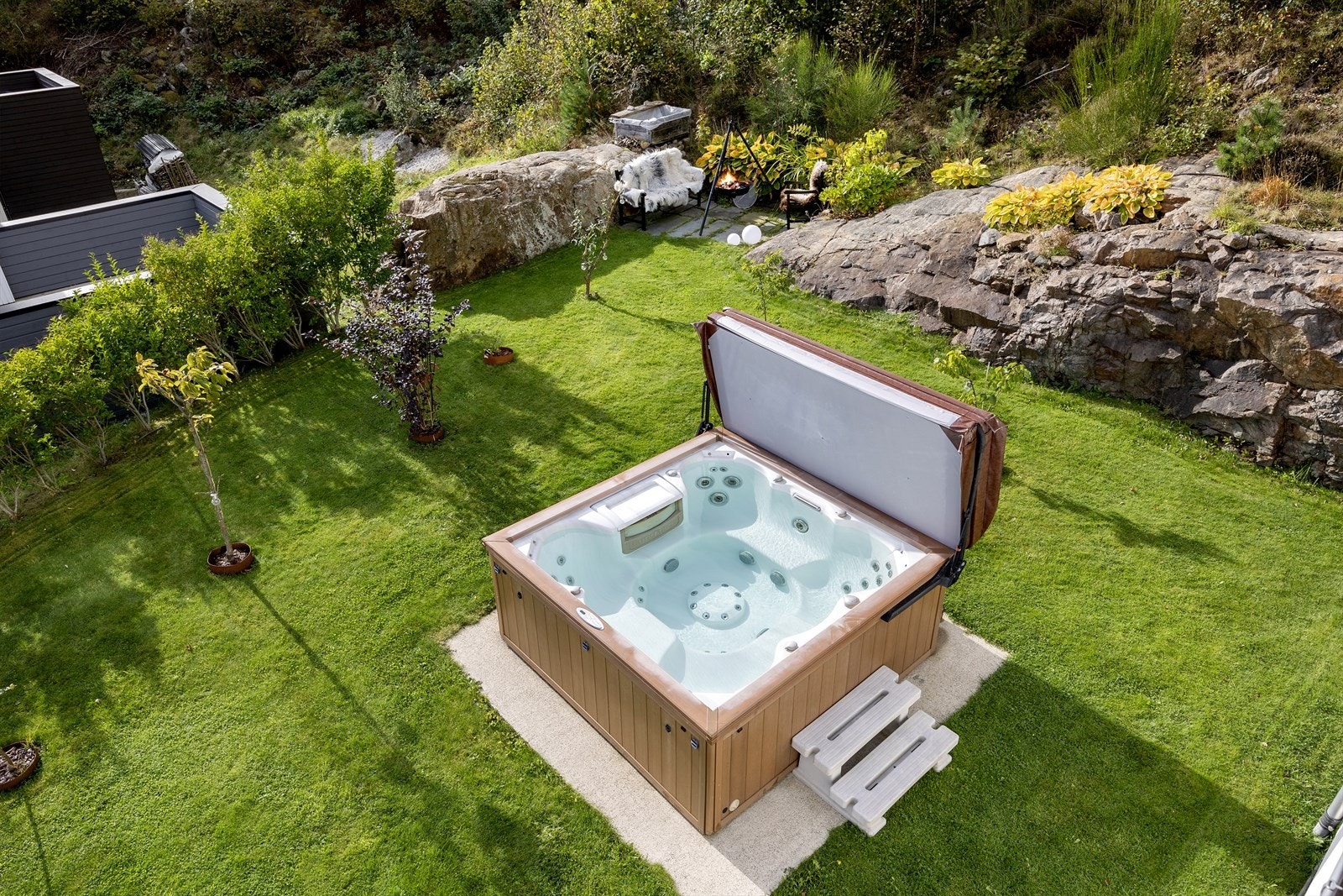 Hagen er pent opparbeidet med plen og beplantning, som gir et harmonisk og innbydende inntrykk. Galleribilde