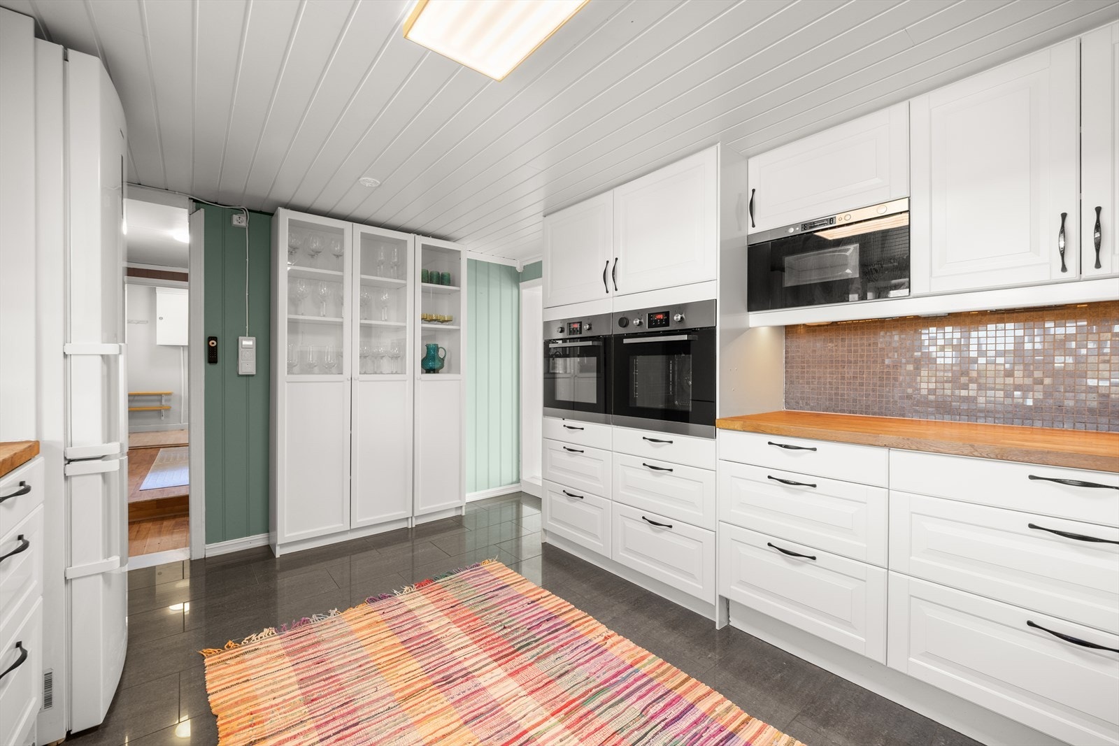 Kjøkkenet er utstyrt med integrert micro, to stekeovner, platetopp fra 2023, kjøl/fryseskap og oppvaskmaskin Galleribilde