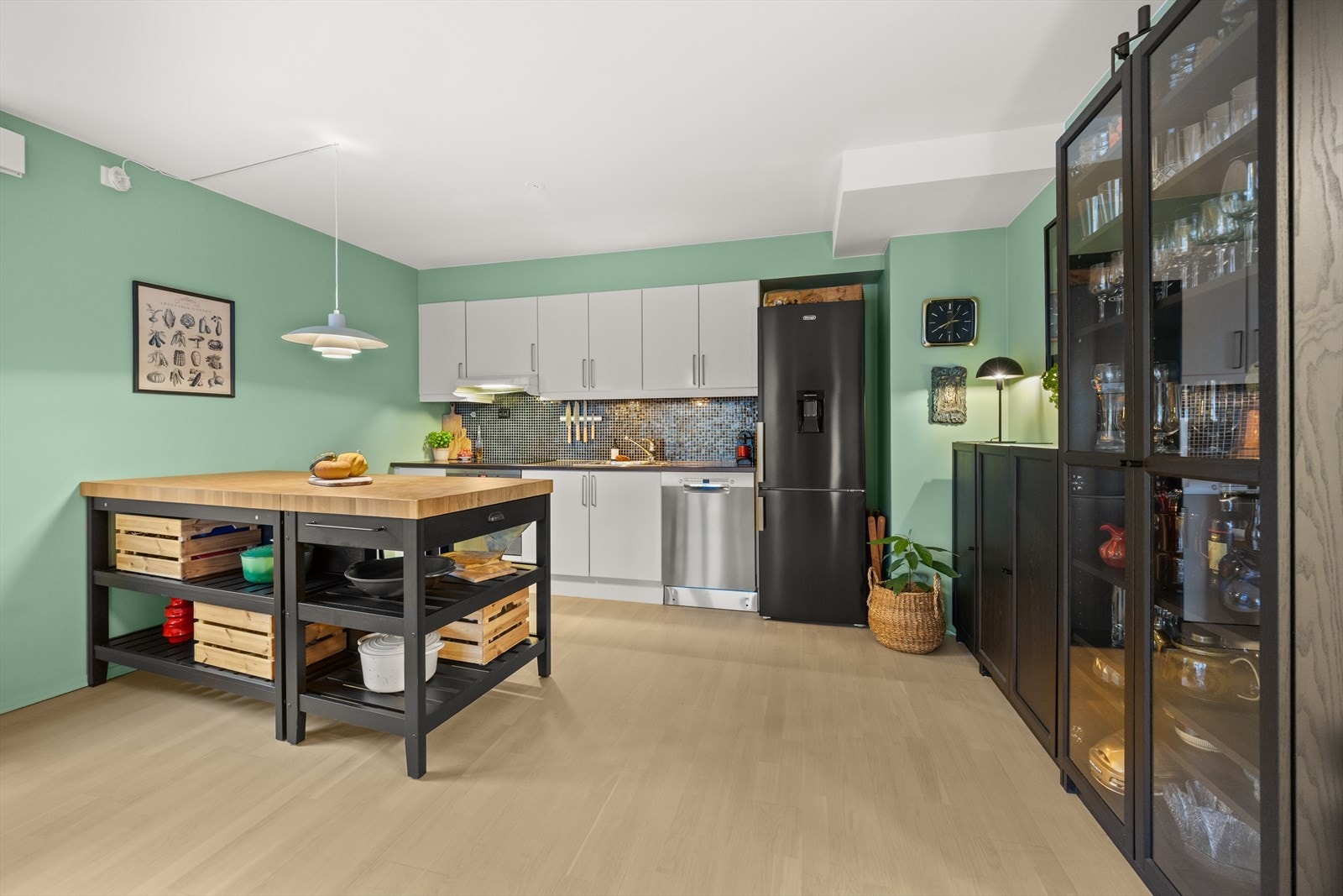 Pent kjøkken med glatte fronter, benkeplate i laminat og flislagt over kjøkkenbenk Galleribilde