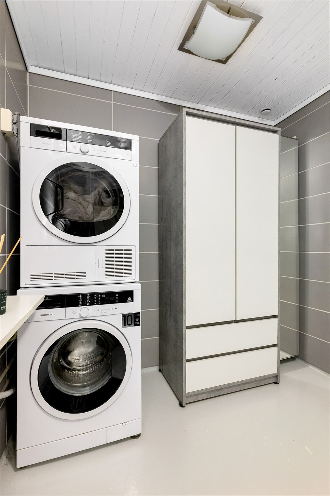 Bad/vaskerom med betonggulv med epoxmaling og fliser på vegg. Galleribilde