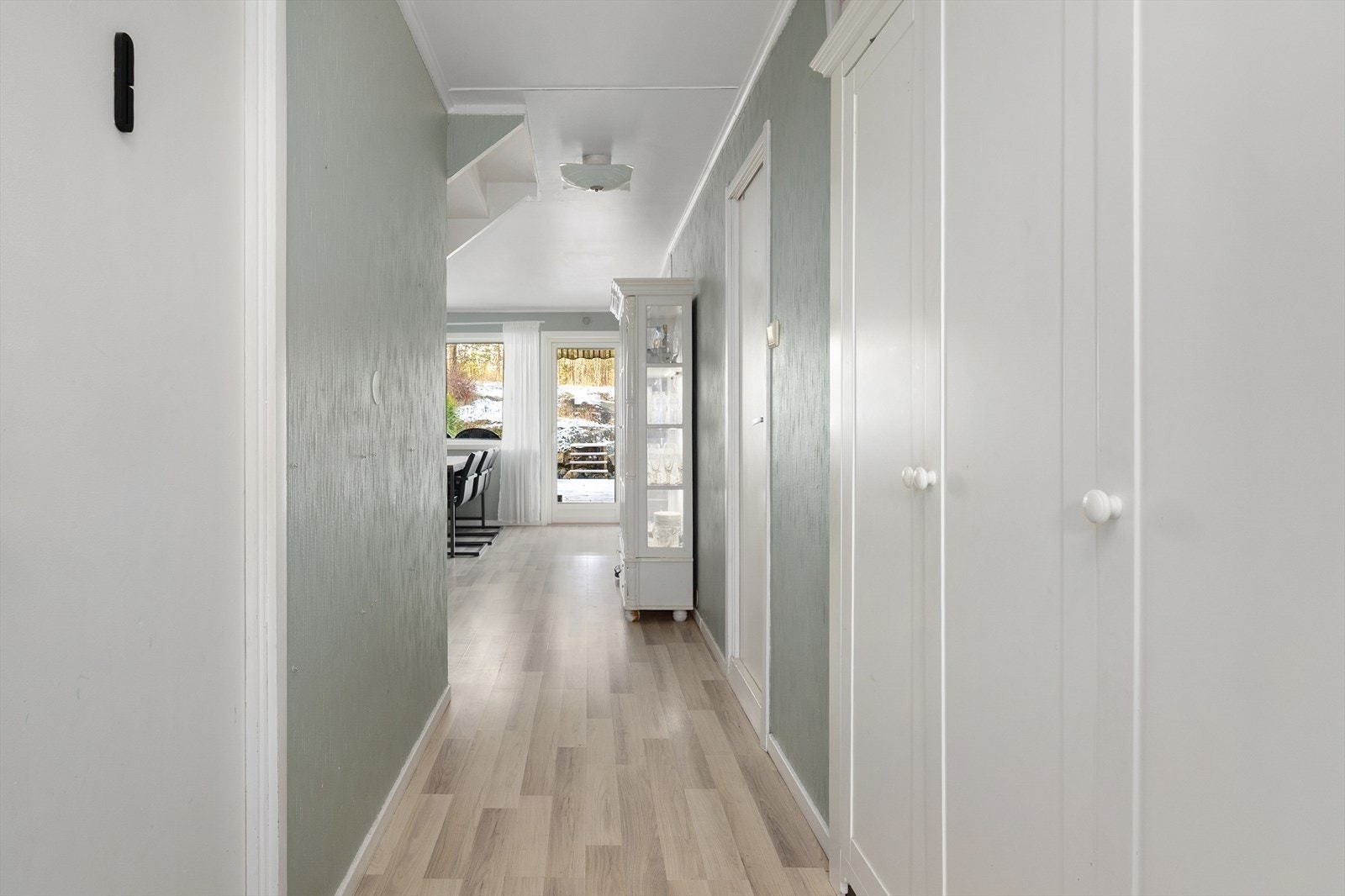 Lys og pen entrè og mellomgang med plass for sko og yttertøy i garderobeskap. Galleribilde