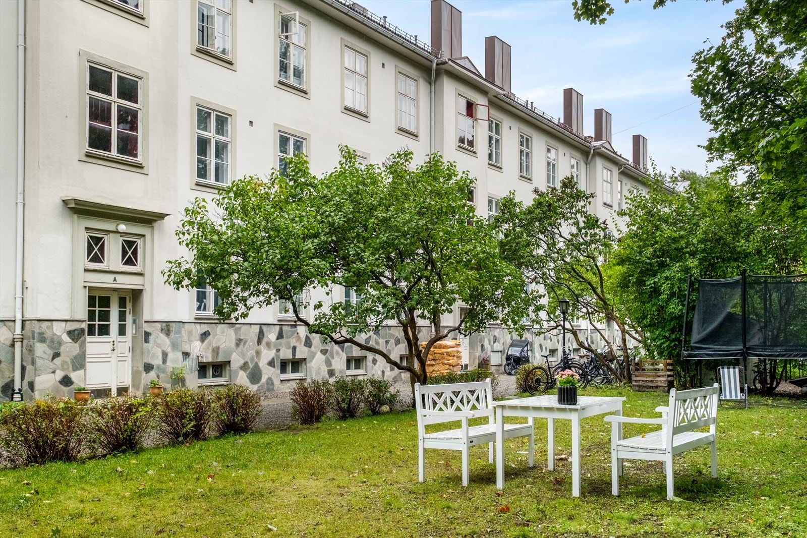 Idyllisk og frodig bakhage med hyggelige sitteplasser. Galleribilde