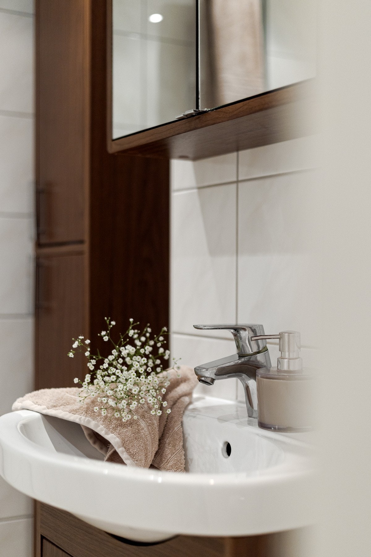 Innredningen består av servant på underskap, speilskap med belysning, skap og vegghengt toalett. Videre er det dusjhjørne med innfellbare glassdører som frigjør plass på gulvet. Galleribilde