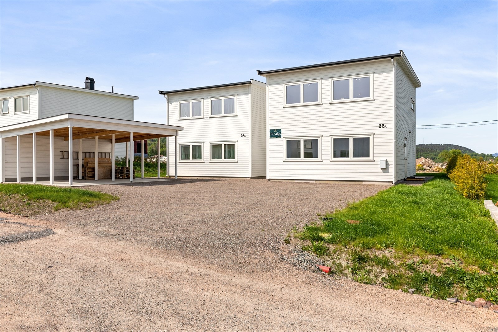 Boligen har uteområde opparbeidet med parkeringsplass, carport med bod og gressarealer Galleribilde