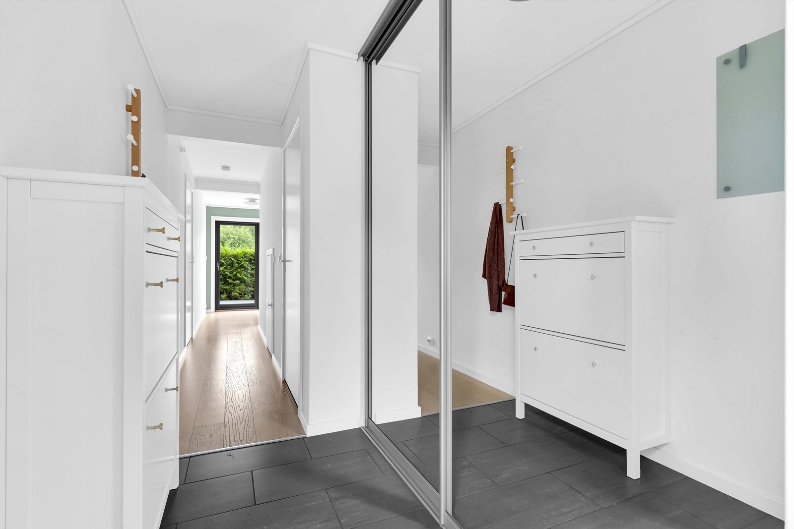 Entréen er romslig og innbydende med god plass til oppbevaring i integrert skyvedørsgarderobe med speilfronter. Hele etasjen har vannbåren gulvvarme som gir jevn og behagelig varme. Galleribilde