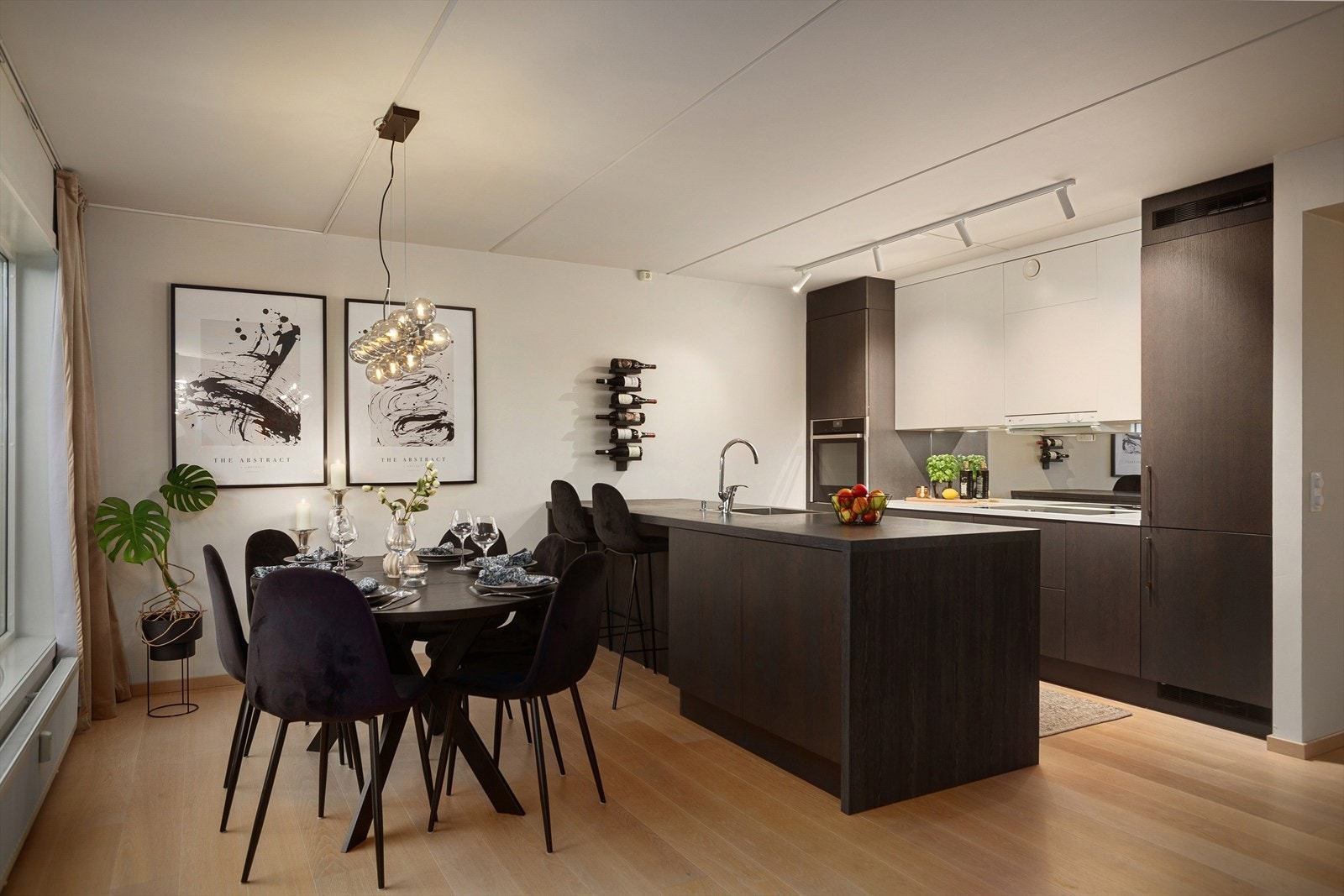 Stue og kjøkken er i en åpen løsning som bidrar til et sosialt og hyggelig oppholdsrom Galleribilde