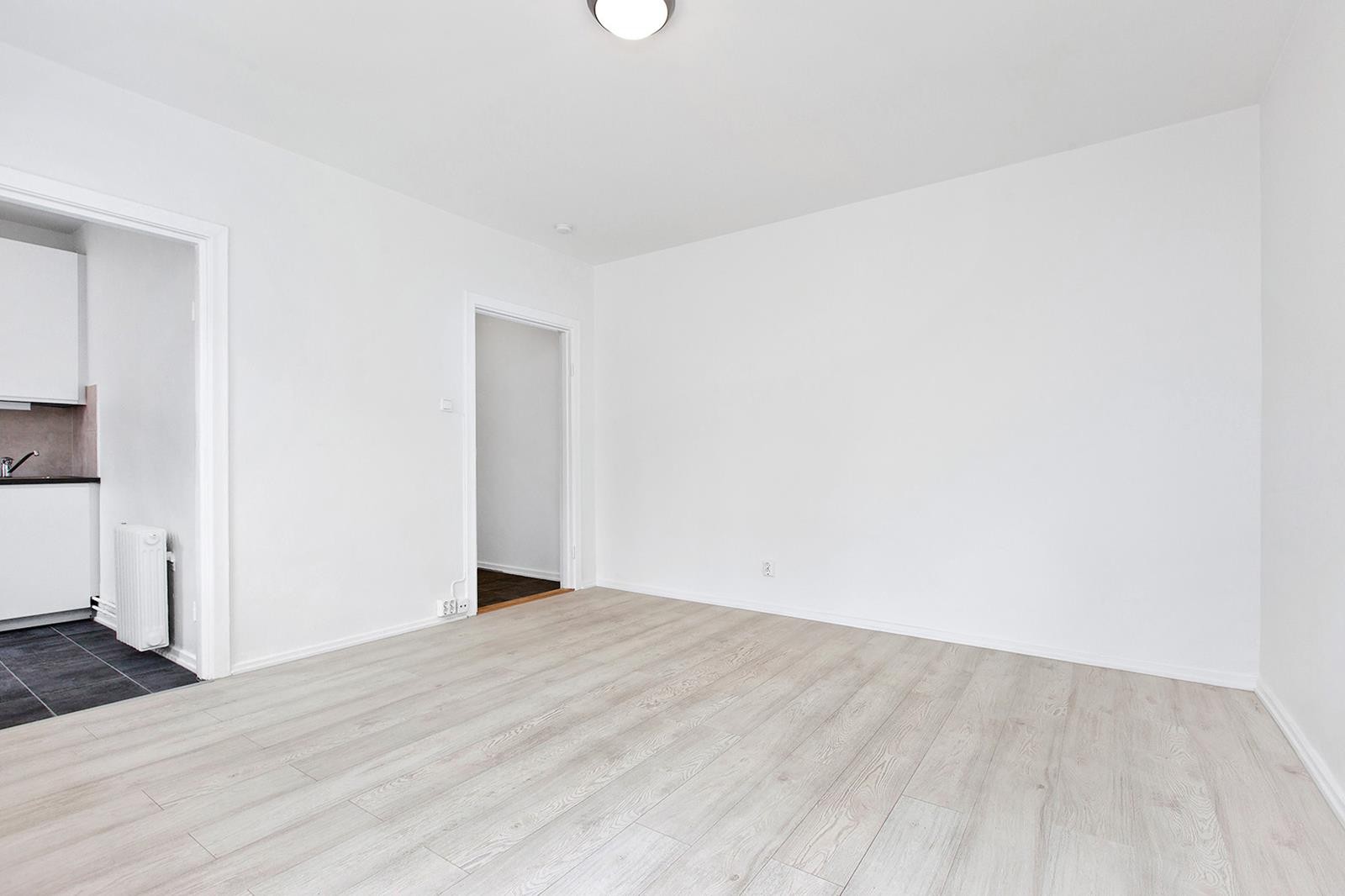 Lys og pen stue med store flater som er enkel å møblere Galleribilde