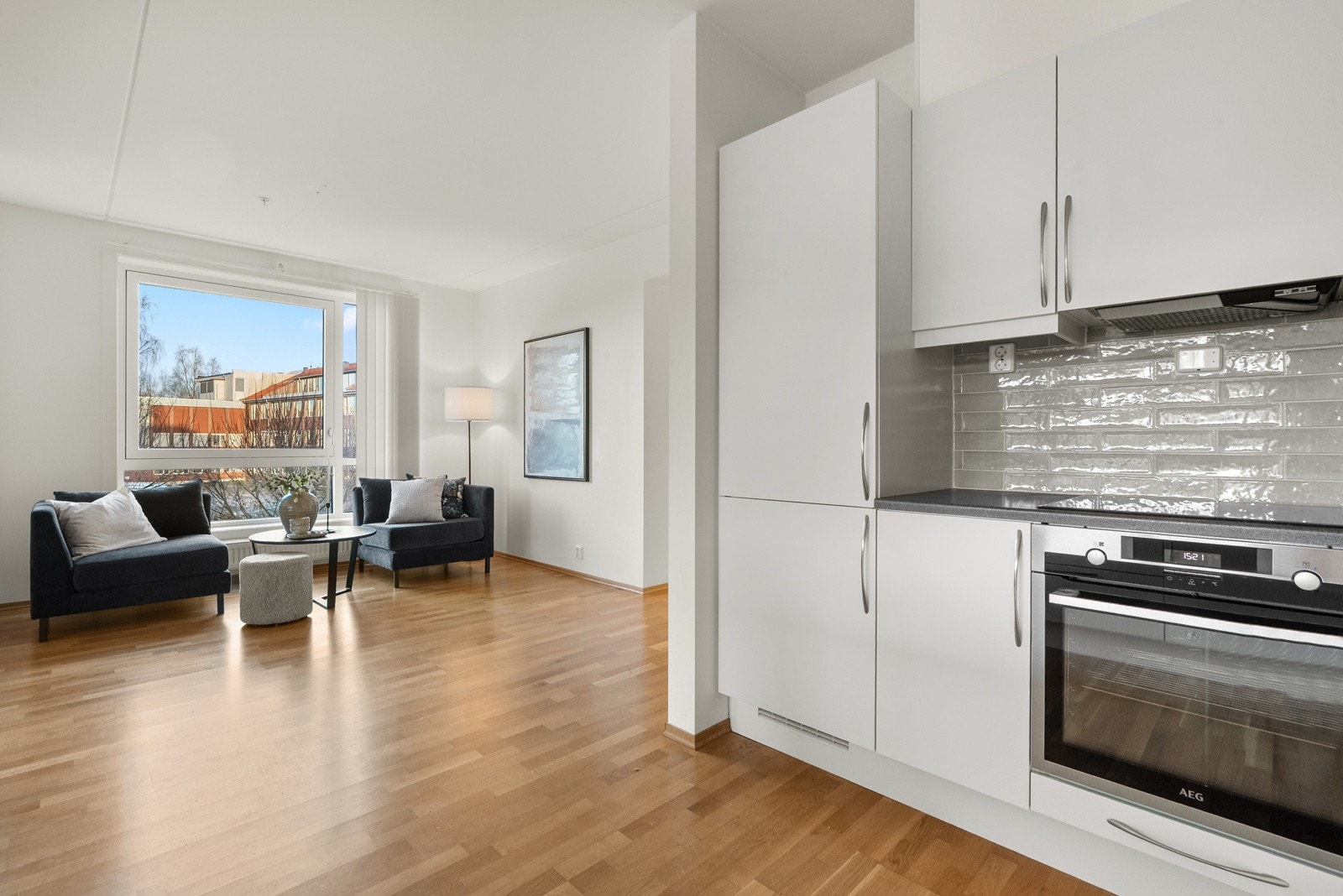 Det er lagt fliser mellom benkeplate og overskap, som sørger for en enklere rengjøring og et pent uttrykk. Galleribilde