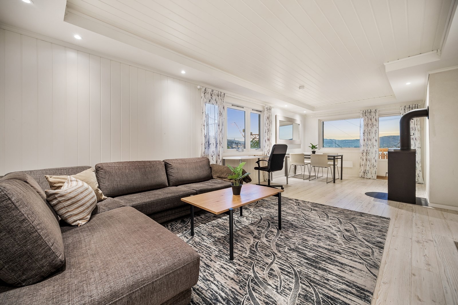 Romslig og pen stue med downlights integrert i lyskasser langs himlingen Galleribilde