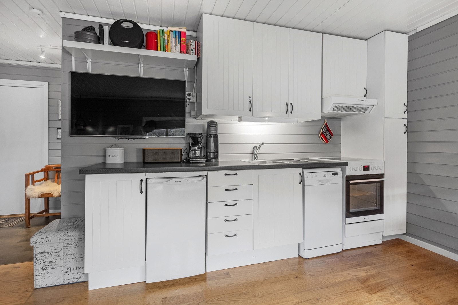 Det er hengt en tv på veggen ved kjøkkenet. Galleribilde