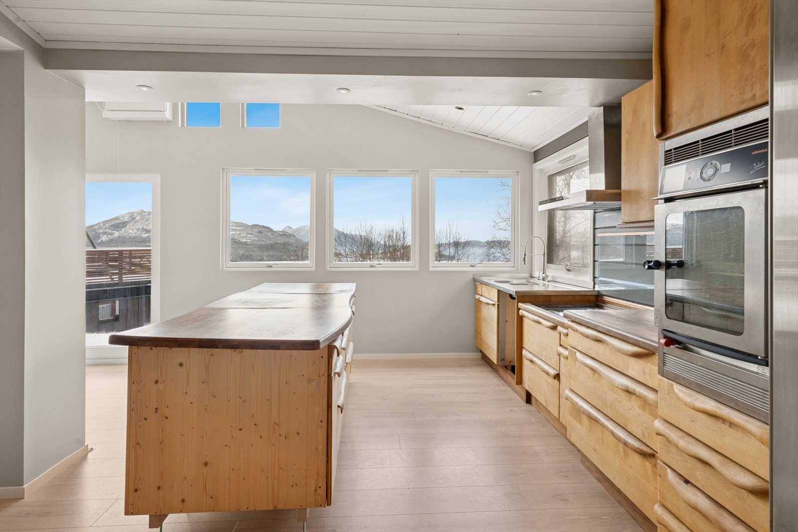 Kjøkken har innredning av håndlaget heltre bjørke-fronter og heltre benkeplate Galleribilde