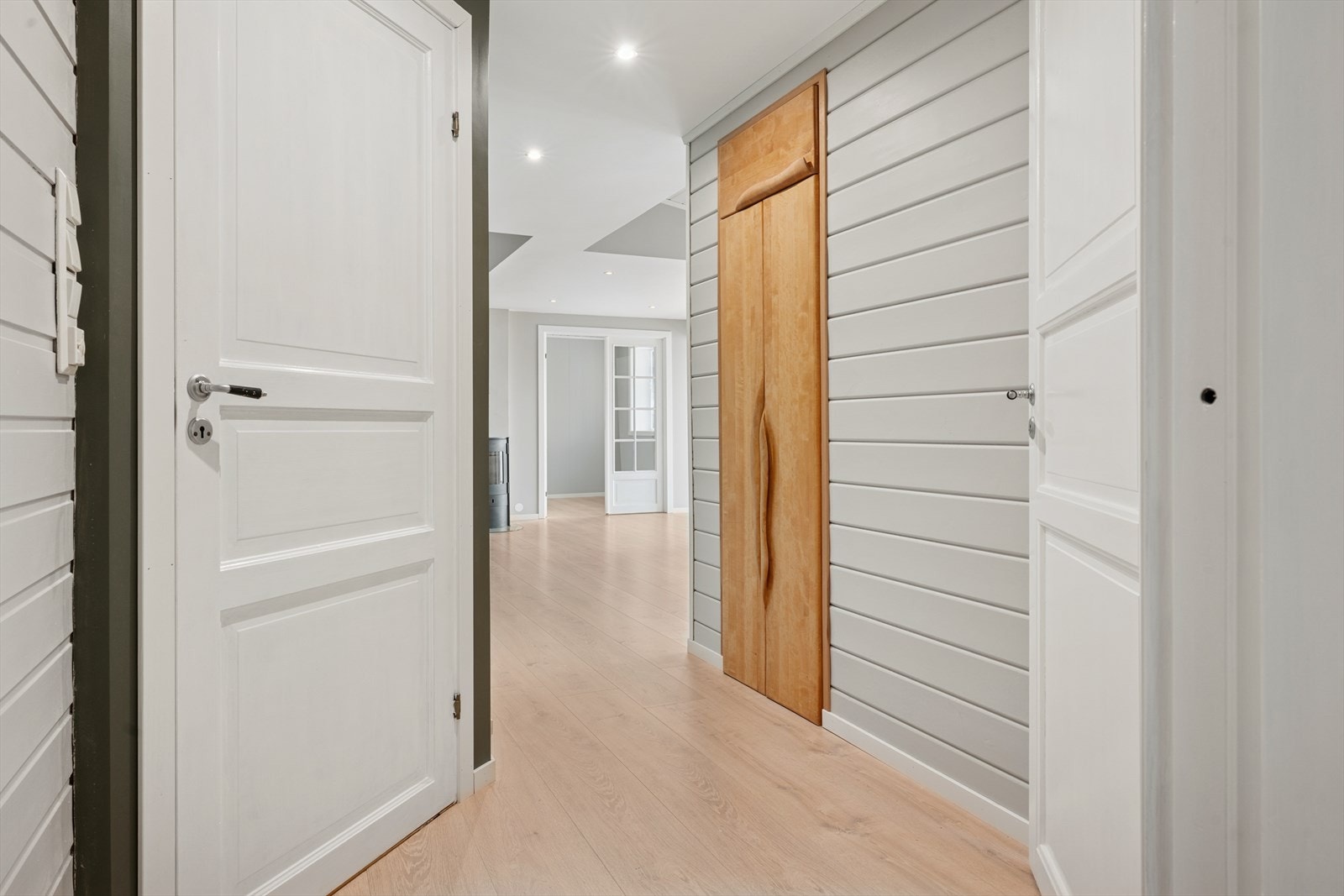 Gangparti med heltre skap med tilsynsrom til kjøleskap. Galleribilde