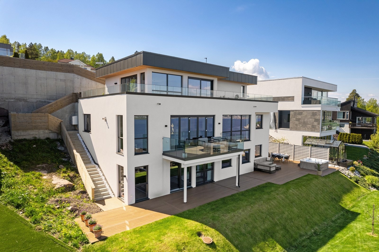 Uteplassene i øverste plan strekker seg rundt to sider, samt er det trappeadkomst ned til hage Galleribilde