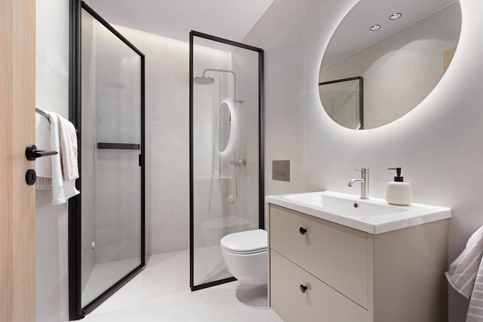 Delikat bad med smijernsdørr, vegghengt toalett og innredning Galleribilde