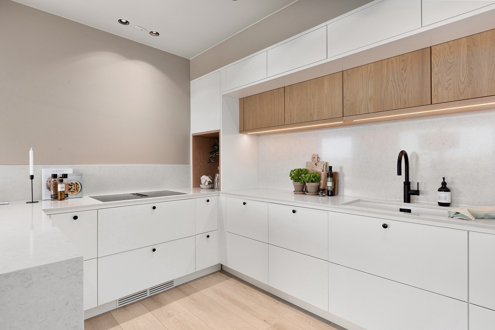 Kjøkkenet har slette fronter og benkeplate i kompositt - legg merke til at dette tas igjen over kjøkkebenk, samt avslutning ned mot gulv Galleribilde