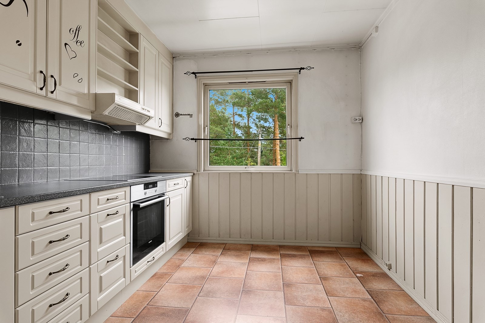 Kjøkkeninnredning med beige, profilerte fronter og laminert benkeplate. Galleribilde