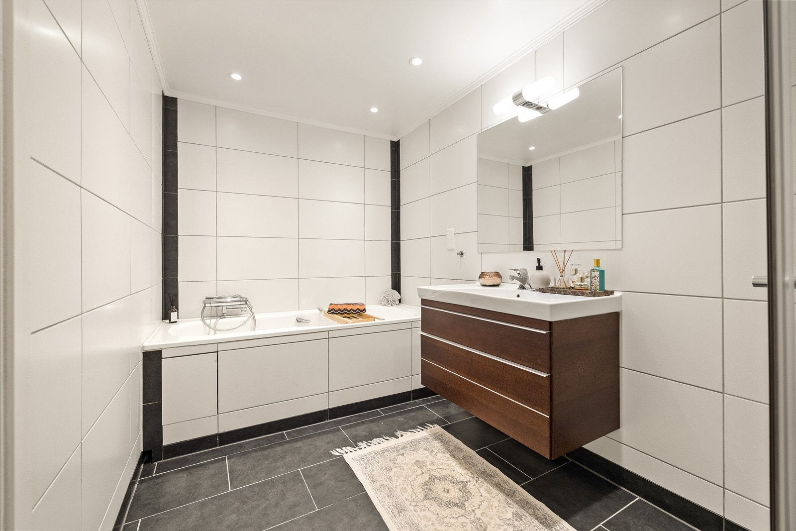 Hovedbadet er flislagt med varmekabler og spotter i tak Galleribilde