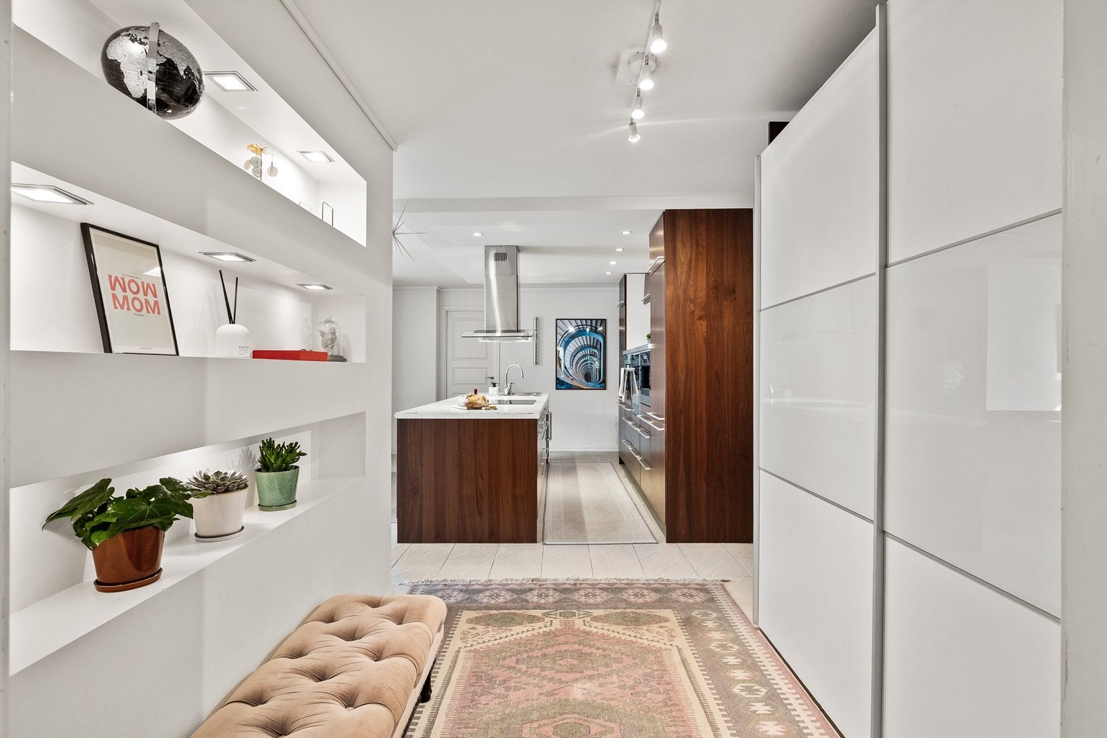 Mellom stue og kjøkken er det liten gang med skyvedørsgarderobe og oppbevaringsnisje i vegg Galleribilde