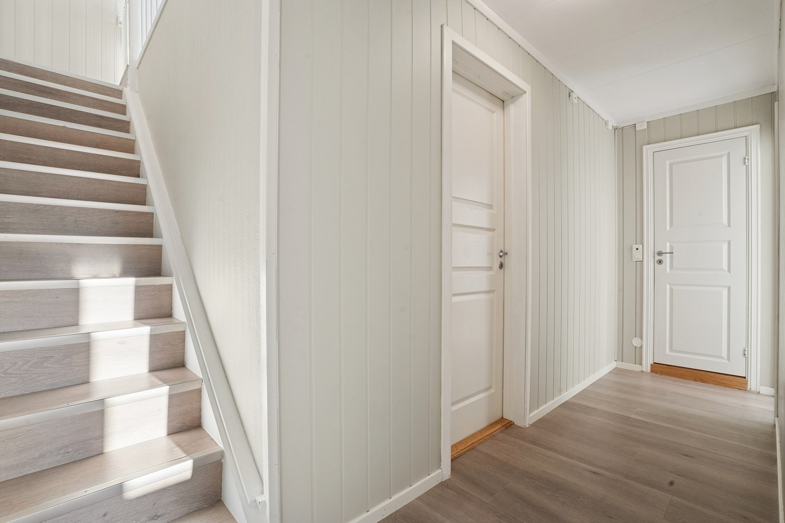 I underetasjen møter du en stor hall ved trappen, tilknyttet en bod under trappen som gir ekstra lagringsplass for sesongvarer eller andre eiendeler. Galleribilde