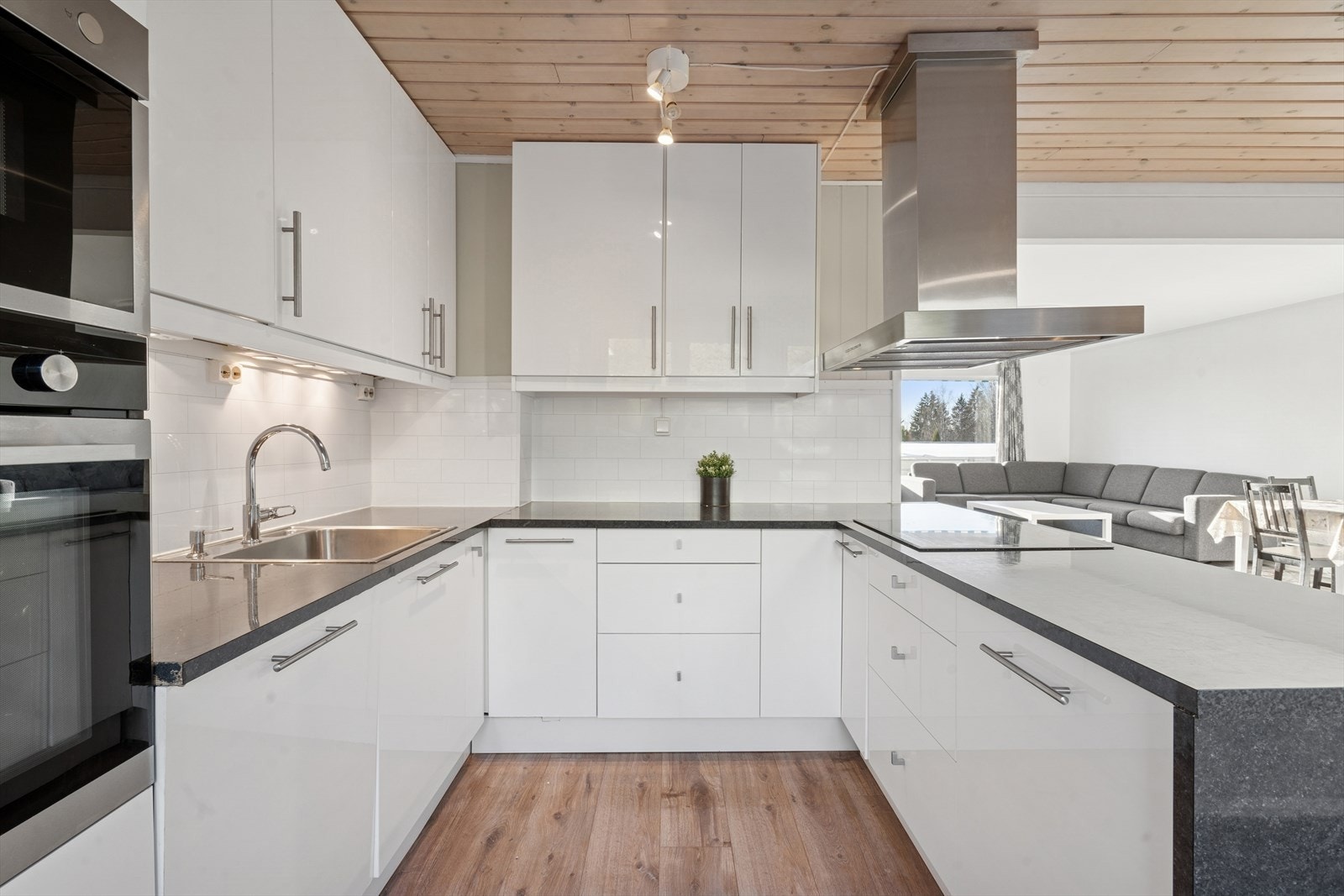 Innredningen består av glatte hvite fronter og ekstra overskap, samt laminat benkeplate med nedfelt stålkum og ettgreps kjøkkenkran. Galleribilde