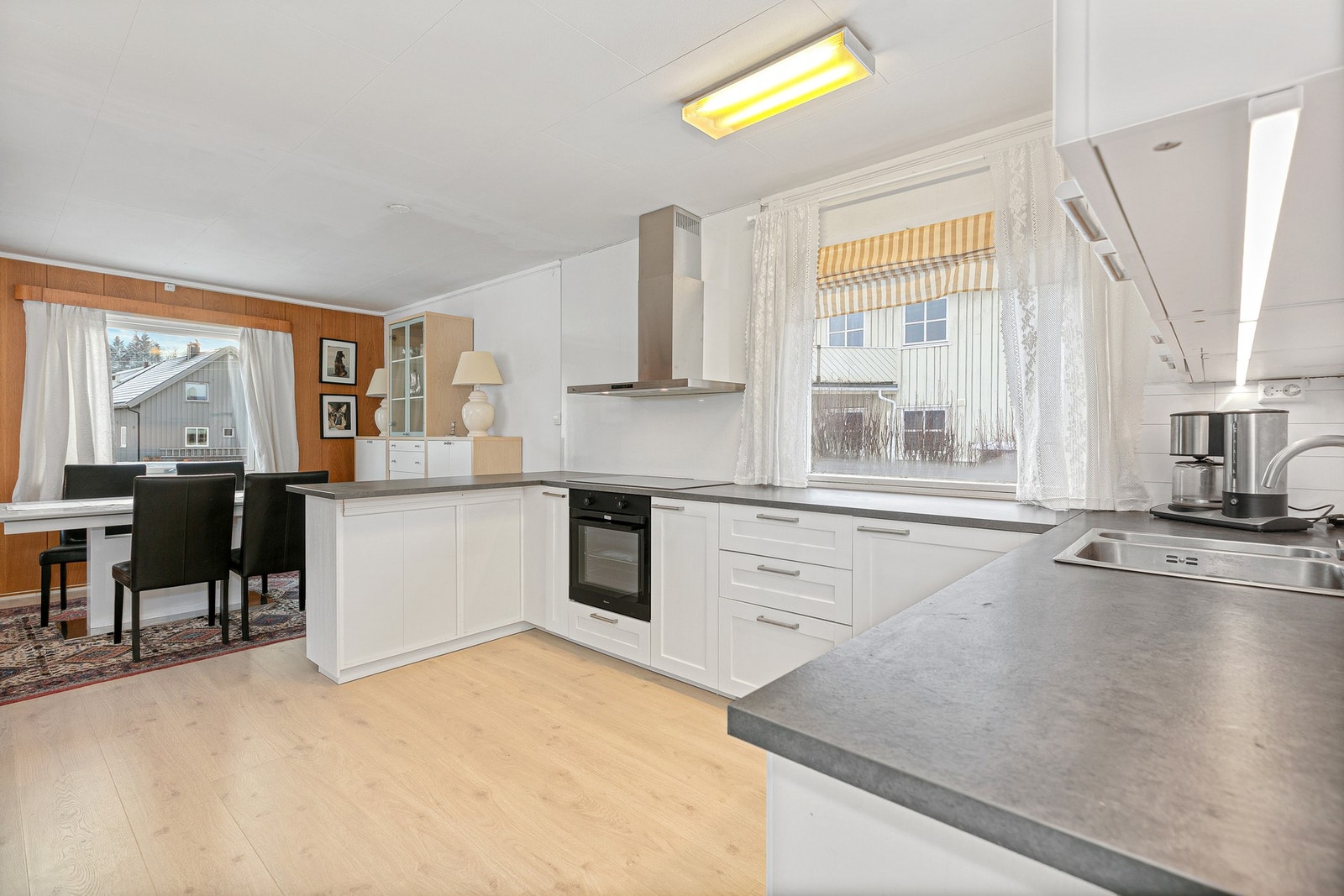 Kjøkkenet fremstår som et moderne og funksjonelt arbeidsrom med profilerte fronter og laminert benkeplate. Galleribilde