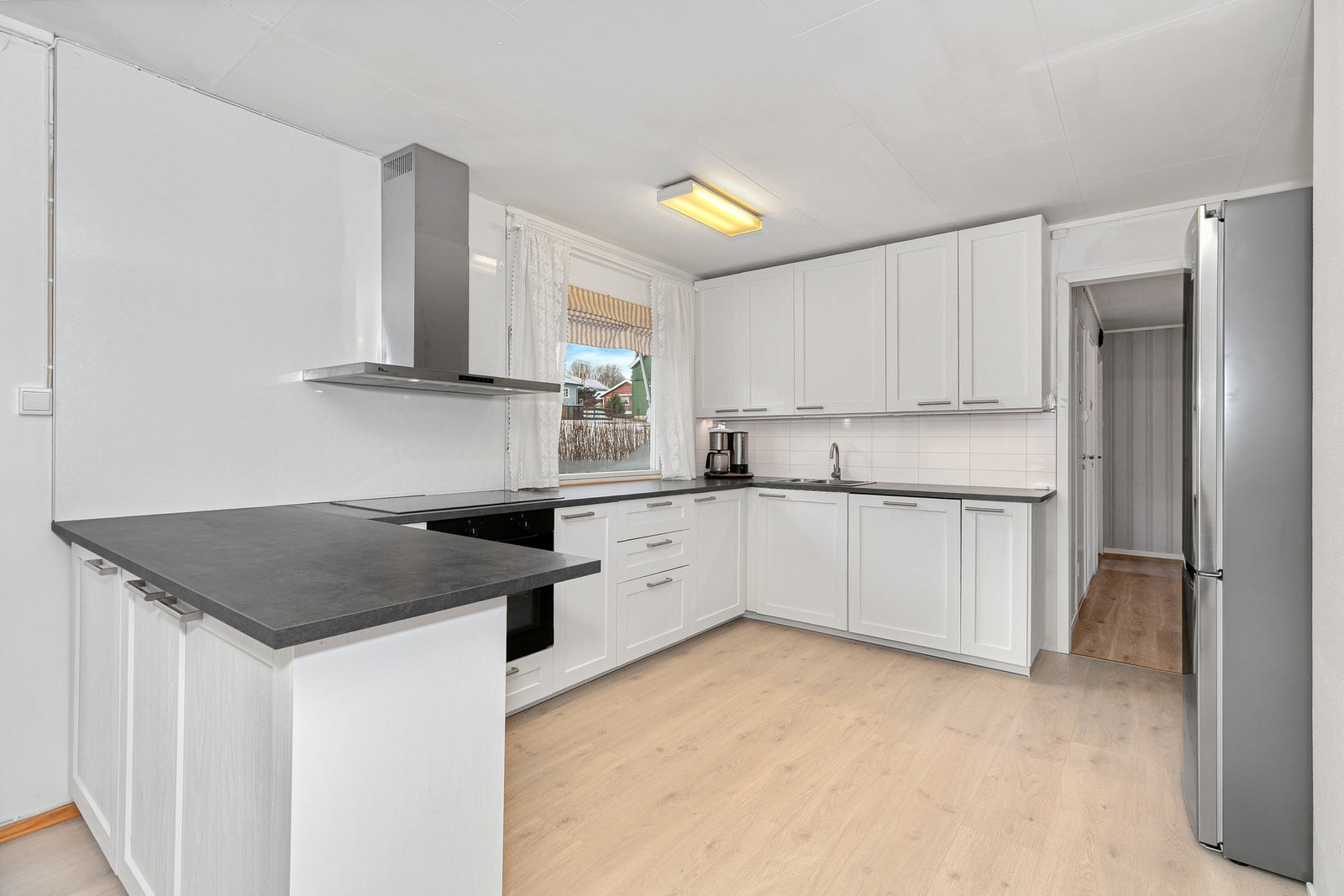 Her finner du integrert stekeovn, platetopp og oppvaskmaskin, samt frittstående kjøleskap og vegghengt ventilator. Galleribilde