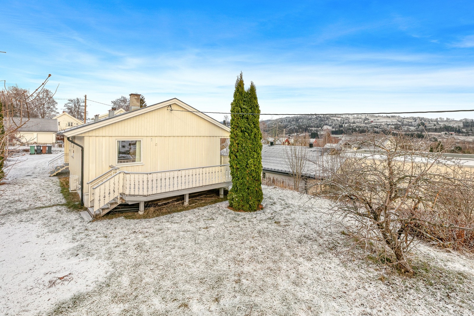 Tomten er lett skrånende, pent opparbeidet med plen og omkranset av etablerte hekker og trær som skaper et lunt og naturlig skjermet utemiljø. Galleribilde