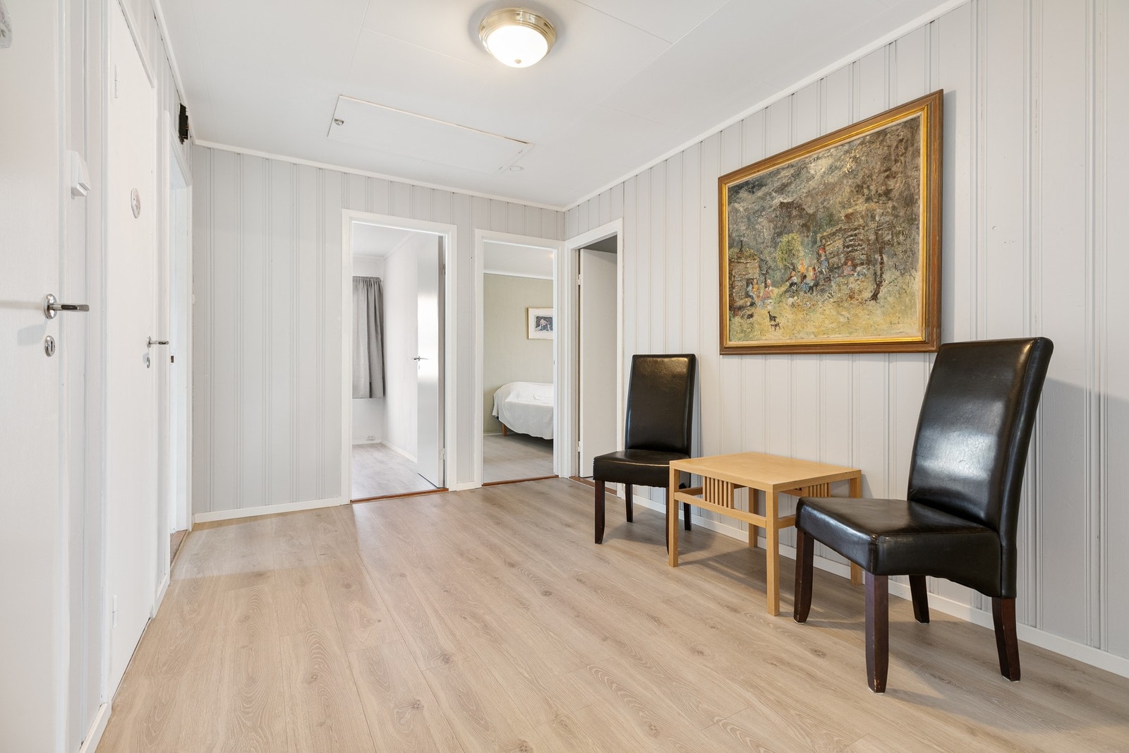 Herfra åpner rommet seg videre inn i en større gang, noe som skaper en naturlig og ryddig flyt inn i resten av hjemmet. Galleribilde