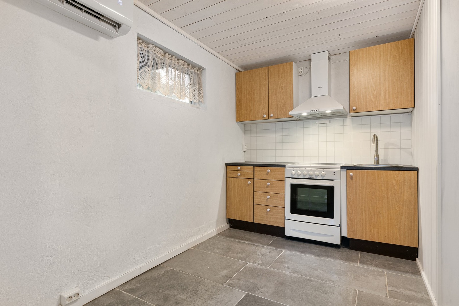 Kjøkkeninnredningen består av glatte fronter, laminert benkeplate, nedfelt vask og frittstående komfyr med komfyrvakt, samt ventilator og gode stikkontakter over benken. Galleribilde