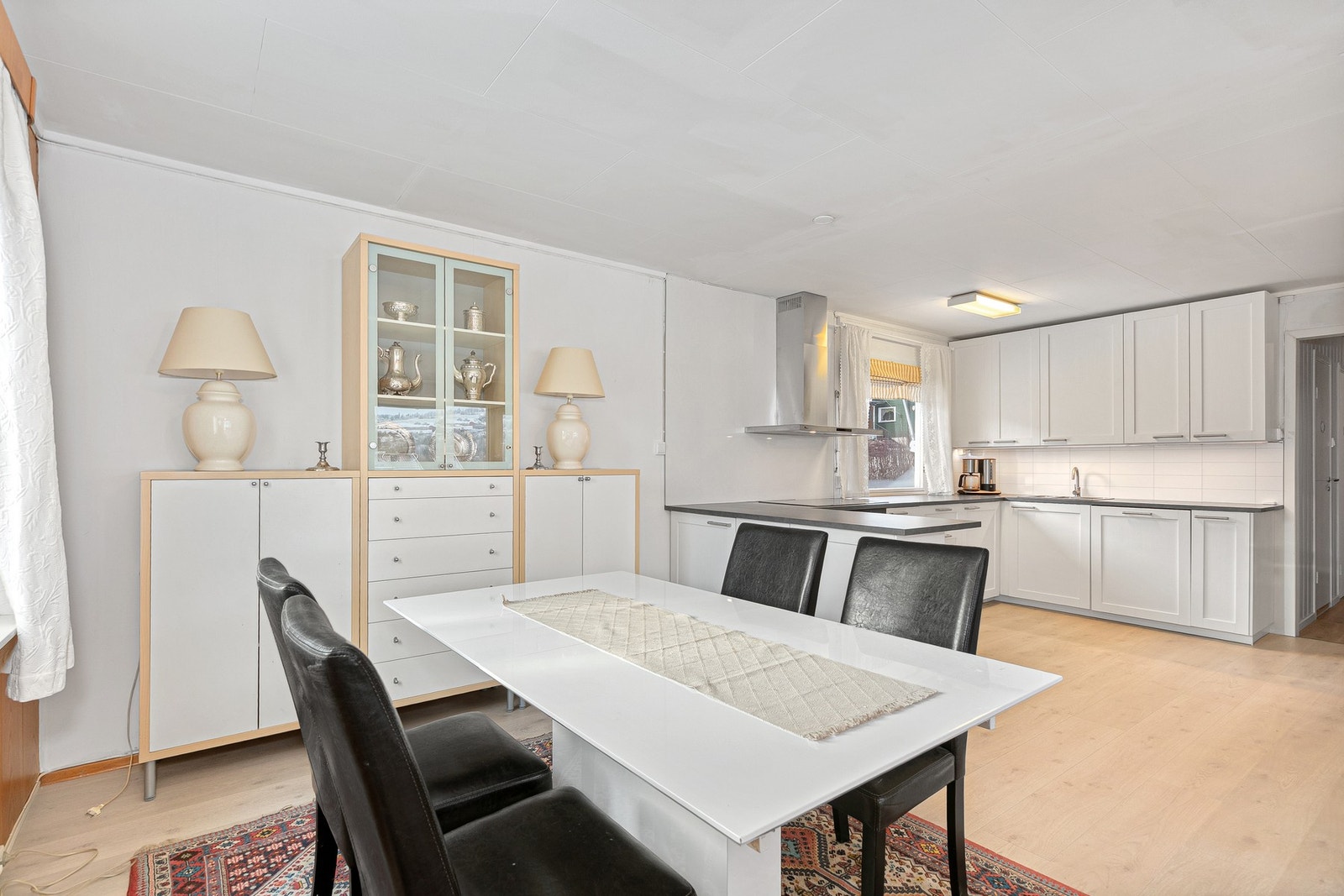 Den delvis åpne løsningen mot kjøkkenet skaper en praktisk og sosial romfølelse hvor hverdagsliv og gjester kan kombineres sømløst. Galleribilde